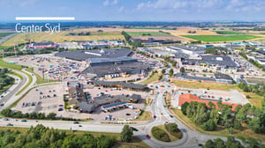 Flygvy över köpcentrumet Center Syd med parkeringsplatser, butiker och omgivande landskap