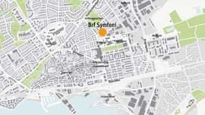 Karta över Ystad med markering för Brf Symfoni nära Surbrunnsparken, biblioteket och Ystad Arena
