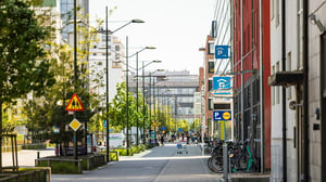 Stadsgata med cykelparkering, parkeringsskyltar och höga byggnader i ett modernt bostadsområde