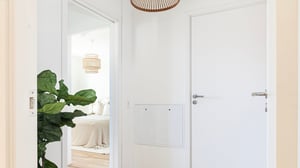 Lägenhet med ljus hall och vit dörr