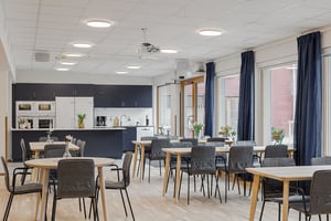 Tomt rum i gemensamhetslokal med kök, matbord och stolar