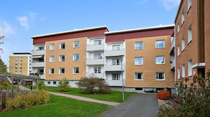 Lägenhetshus med grön innergård och gångväg