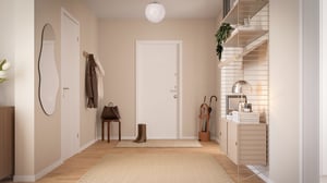 Hall med ljus inredning, spegel, hatthylla och förvaring i modern lägenhet