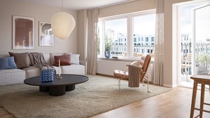 Lägenhet med ljust vardagsrum, soffa, fåtölj och stora fönster med utsikt
