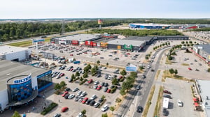 Flygfoto över ett handelsområde med stora varuhus, parkeringar och många bilar
