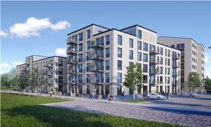 Modern flerfamiljshus med fasader i ljus färg, stora fönster och balkonger, omgivna av grönområden och gångvägar
