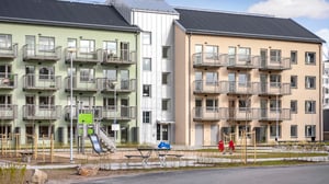 Flerbostadshus med balkonger och lekplats på gården