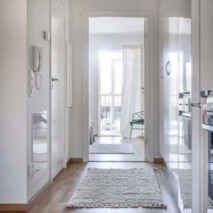 Inflyttningsklar lägenhet med ljus hall, vita skåp och parkettgolv