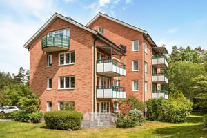 Flerbostadshus i tegel med stora balkonger mot grönområde