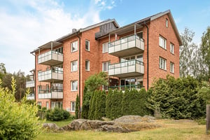 Flerbostadshus i tegel med stora balkonger mot grönområde