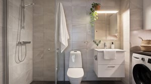 Modernt kaklat badrum med dusch, toalett, handfat och tvättmaskin