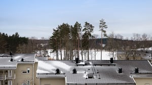 Vy över Korseberg Vik med snötäckta hustak och träd i bakgrunden