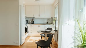 Inflyttningsklar lägenhet med ljust kök, matplats och svarta stolar