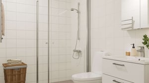 Badrum med dusch, toalett och handfat i ljusa material