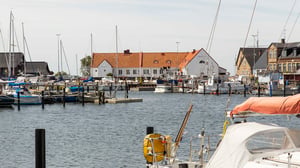 Hamnar med segelbåtar och byggnader vid vattnet