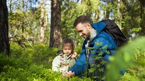 Pappa med barn i skogen