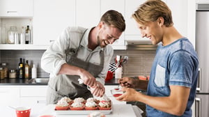 Två ung killar bakar muffins.ar mat