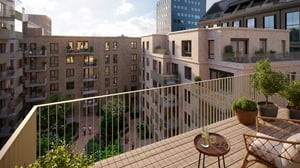 Balkong med utsikt över en modern innergård omgiven av ljusa tegelbyggnader, grönska och sittplatser