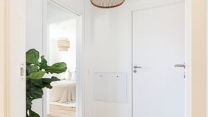 Lägenhet med ljus hall och vit dörr