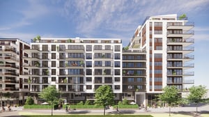 Modern flerbostadshus med balkonger, stora fönster och grönskande innergård