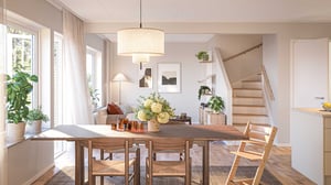 Ljust vardagsrum med matplats, stora fönster, trappa och inredning i ljusa neutrala färger