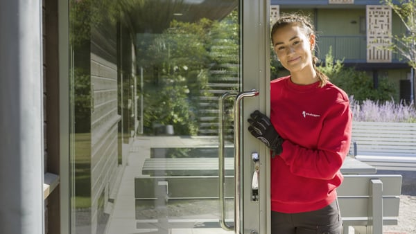 Fastighetsförvaltare som håller upp en entrédörr