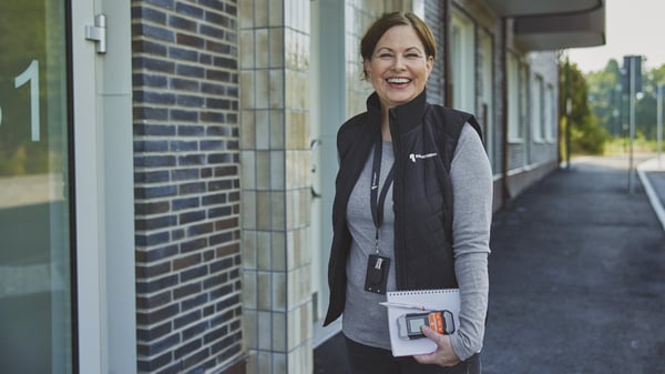 En teknisk förvaltare från Riksbyggen utanför en förvaltad fastighet