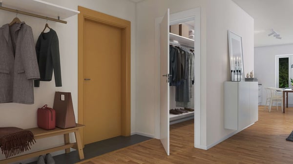 Hall med trägolv, ytterkläder på en klädhängare, en bänk med väska och filt, öppet förråd med kläder, och dörr till matsal i bakgrunden