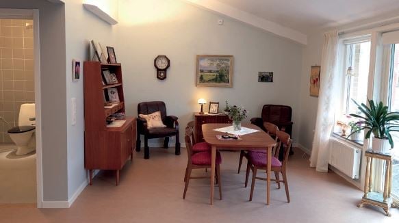 Inflyttningsklar lägenhet med vardagsrum, matbord och stora fönster