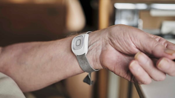 Närbild av en persons arm med en vit aktivitetsmätare på handleden