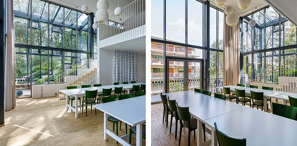 Gemensamhetslokal  med ljusa, öppna ytor, stora fönster och gröna stolar vid vita bord