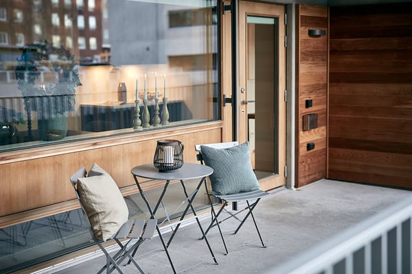 Lägenhet med möblerad balkong och två stolar vid ett litet bord