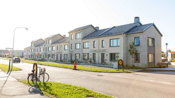 Rad med nybyggda radhus i ett bostadsområde längs en gata