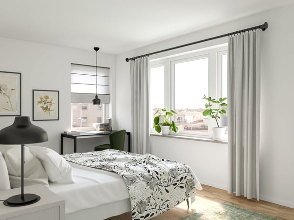 Lägenhet med sovrum, skrivbord, växter och stora fönster med ljusa gardiner