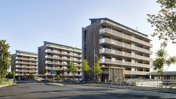 Lägenheter i flerbostadshus med balkonger och grönska utanför