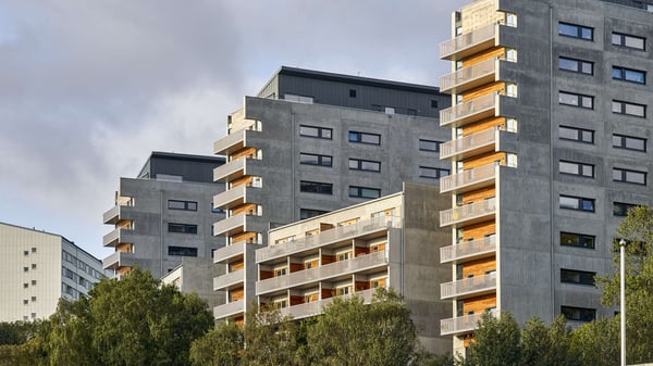 Flerbostadshus med moderna balkonger och fasader i grått och trädetaljer