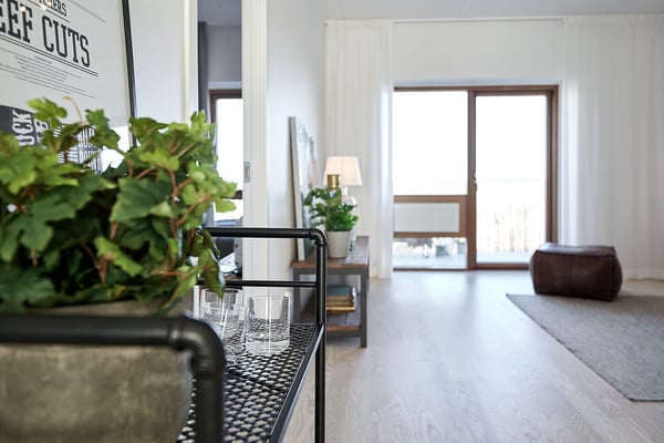 Lägenhet med ljus öppen planlösning, stora fönster och inredda detaljer