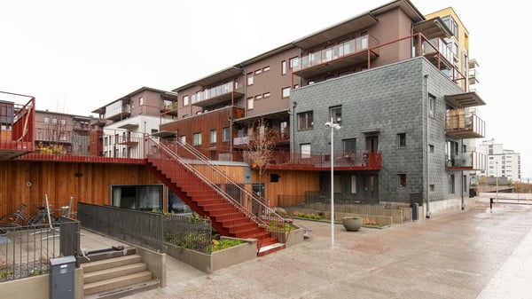 Flerbostadshus med träfasad, röda trappor och balkonger