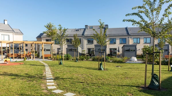 Nyproducerade radhus med grön innergård, lekplats och unga träd