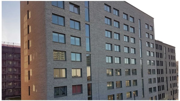 Flerbostadshus i  tegel med många fönster