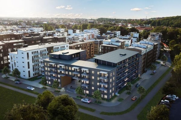 Flygvy över moderna flerbostadshus med bostadskvarter och gröna omgivningar