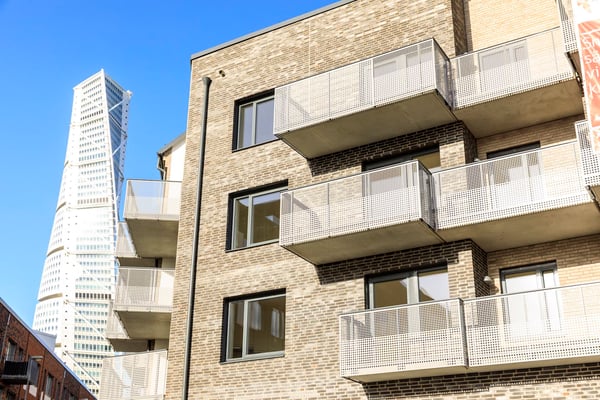 Flerbostadshus med balkonger och den snurrande skyskrapan Turning Torso i bakgrunden
