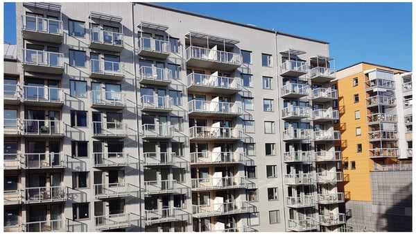 Bostadshus med flera balkonger och lägenhetsfönster i dagsljus