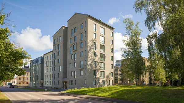 Flerfamiljshus i stadsmiljö med grönytor och träd