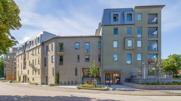 Flerfamiljshus med moderna lägenheter och balkonger vid en lugn gata