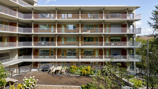Flerfamiljshus med balkonger och gemensam uteplats i ett modernt flerbostadshus
