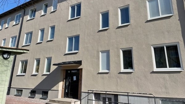 Flerfamiljshus med beige fasad och många fönster