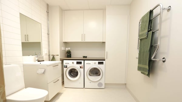 Inflyttningsklar tvättstuga med tvättmaskin, torktumlare, handfat och handdukstork