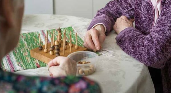 Två personer spelar ett brädspel vid ett bord