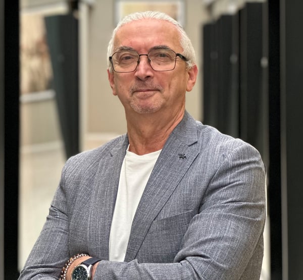 Porträtt av en man i grå kavaj och vit tröja